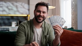 Smiling happy Caucasian business man male guy homeowner businessman showing house apartment key keychain holding money cash dollars selling real estate housing mortgage buying new home in living room - Powered by Shutterstock - Get 15% off with code: PIKWIZARD15