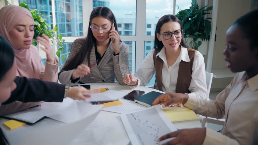 Business meeting chaos stress discussion multiethnic women stressed angry females group girls coworkers businesswomen arguing about project startup documents paperwork fail bad result indoors office