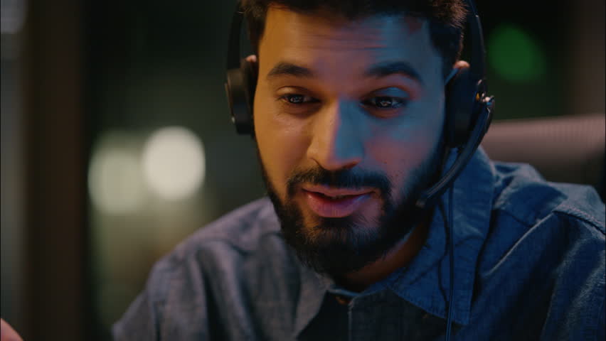 Indian business man guy male businessman helpline manager in headset consultation in call center online communication telemarketing sales talking distant helping customer support in dark night office - Powered by Shutterstock - Get 15% off with code: PIKWIZARD15