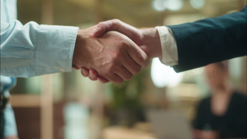 Close up hands shaking men business partners guys meeting in office greet businessmen teamwork cooperation handshaking two male colleagues arms handshake partnership bank deal agreement hire candidate