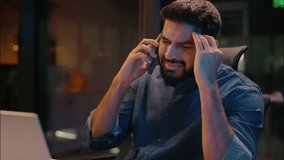 Indian angry annoyed businessman scream shout night late in office talking mobile phone male Arabian guy business man entrepreneur call smartphone problem conversation conflict arguing laptop working - Powered by Shutterstock - Get 15% off with code: PIKWIZARD15