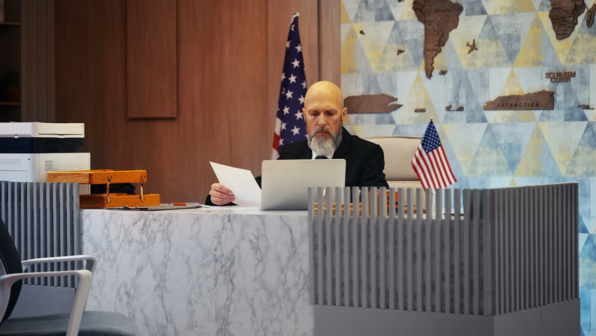 Senior US embassy worker reviewing visa applications in office, doing paperwork