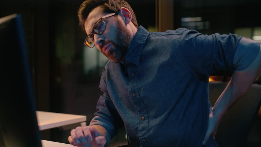 Caucasian business man guy professional employer manager at dark night office overworked feel backache sedentary computer work back pain tired male businessman hurt discomfort overload health problem