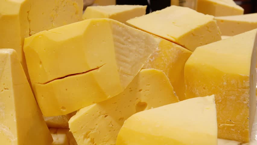 Bright yellow cheese blocks displayed at the market