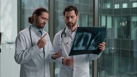 Two professional Caucasian doctors males men students interns medical people radiologist surgeon therapist discussing lungs xray image medicine talking patient treatment hospital clinic health center - Powered by Shutterstock - Get 15% off with code: PIKWIZARD15