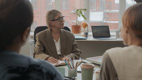 Over the shoulder shot of middle-aged businesswoman leading sustainable energy team meeting, discussing ideas with female colleagues in office - Powered by Shutterstock - Get 15% off with code: PIKWIZARD15
