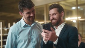 Happy businessmen colleagues friends male business partners guys fellows Caucasian men funny laughing together use mobile phone in office break humor meet friendship laugh smartphone message good news - Powered by Shutterstock - Get 15% off with code: PIKWIZARD15