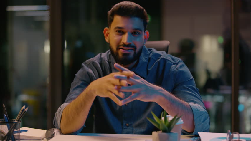 Indian man smiling positive guy male business coach businessman mentor influencer leader entrepreneur HR manager at dark night office talking to camera consultation motivation speech teaching consult