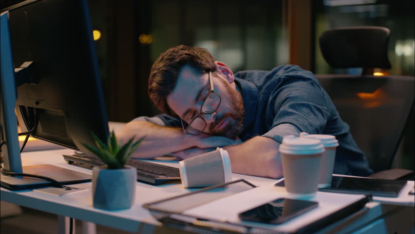 Caucasian guy sleeping tired businessman sleep nap at dark night office lost health problem insomnia overtime male business man workaholic overworked exhausted awake stressed typing computer deadline