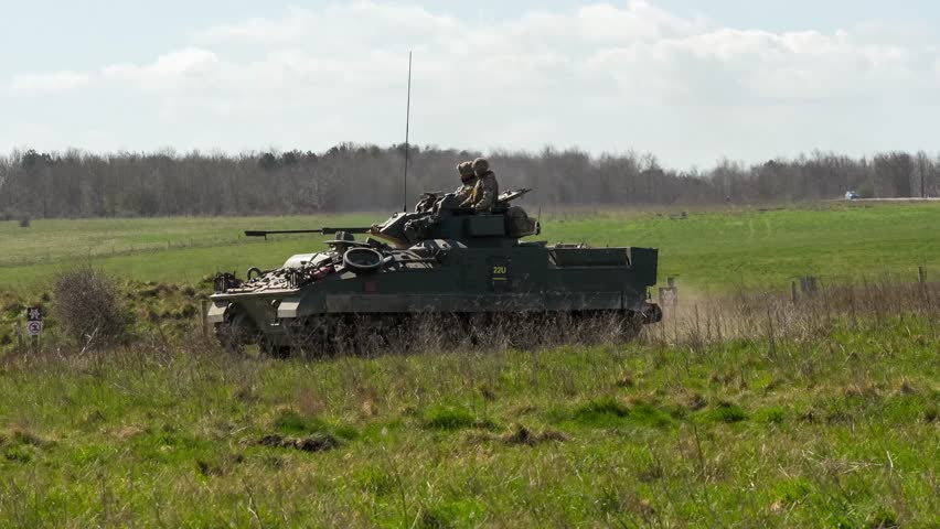 close-up of a commander and gunner directing a British army Warrior FV510 IFV in action on a military exercise