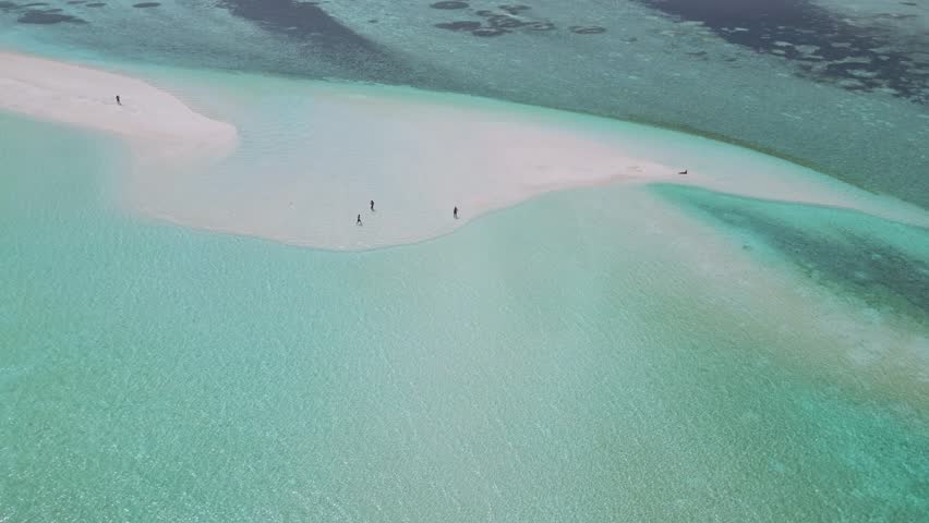 Aerial view of sandbank near Thulusdhoo island.Maldives.Group of people walking on white sandy sandbank at hot sun day.Slow motion video