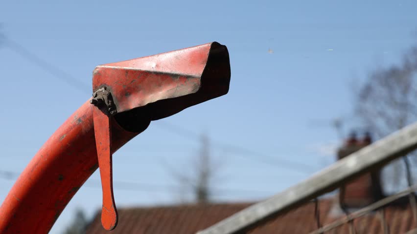 Close up of wood chippings coming out of an outer chute, discharge spout of a wood chipper 