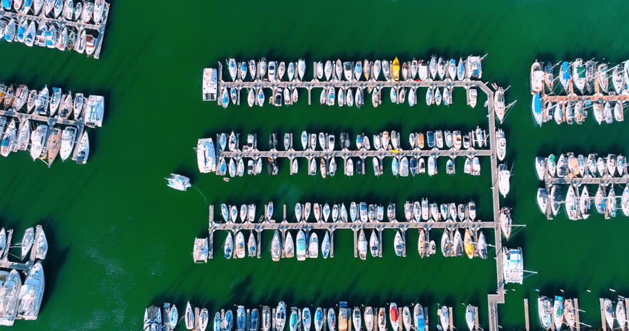 Numerous yachts at the piers on the green waterscape. Top view. Yacht club in Hawaii, USA.