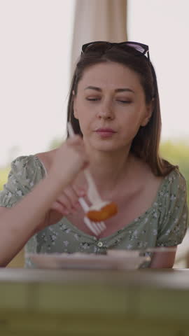 Mother and little girl eat delicious cottage cheese pancakes in resort restaurant closeup slow motion. Dessert of healthy ingredients. Cafe menu
