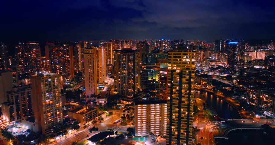 Footage at the tops of the high-rise buildings of Honolulu, Hawaii, USA. Lively, shining city view at night.