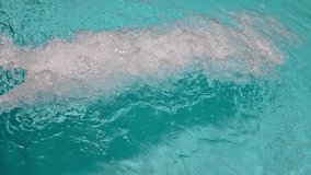 close-up video of turquoise swimming pool water rolling and splashing from the end of a waterslide on an otherwise smooth rippled surface. sunny day fun recreational landscape with sound. - Powered by Shutterstock - Get 15% off with code: PIKWIZARD15