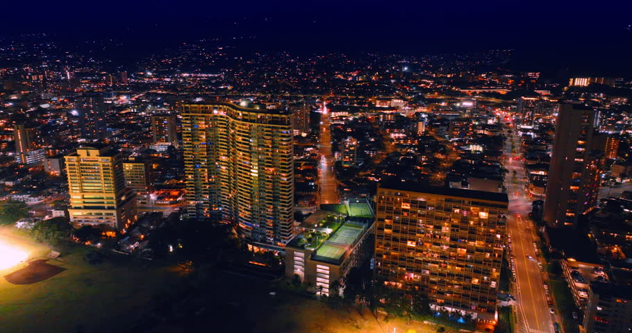 Luminous panorama of a gorgeous cityscape at night. Vast view of Honolulu, Hawaii, USA from drone.