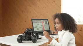 African girl pointing at car model structure while work on laptop. Student inspect at STEM education class. Panorama shot of Clever child using laptop to write programing engineer code. Erudition. - Powered by Shutterstock - Get 15% off with code: PIKWIZARD15