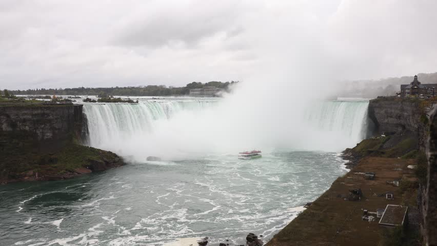 Niagara Falls with tour boat near Horseshoe Falls on a cloudy day in Ontario, Canada.
