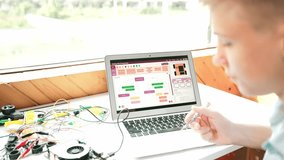 Caucasian student looking at laptop screen while coding engineering prompt or programming system. Back view of teenager working by using computer and electronic tool repair main board.. Edification - Powered by Shutterstock - Get 15% off with code: PIKWIZARD15