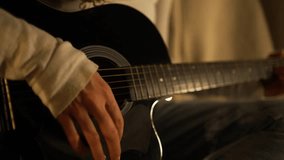 Close-up montage showcasing a musician's hands skillfully strumming and fingering the chords of a black acoustic guitar, creating a rhythmic and melodic sequence - Powered by Shutterstock - Get 15% off with code: PIKWIZARD15