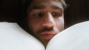 Young man overwhelmed and confused while reading a book, making exaggerated facial expressions as he tries to comprehend complex information in a dramatic close-up scene - Powered by Shutterstock - Get 15% off with code: PIKWIZARD15