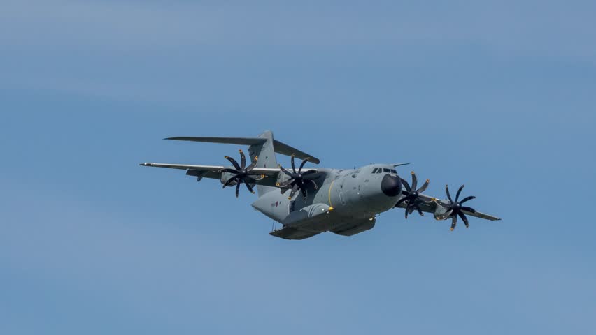 RAF Royal Air Force Airbus C.1 A400M Atlas military cargo plane on a low-level cargo parachute drop exercise, blue sky