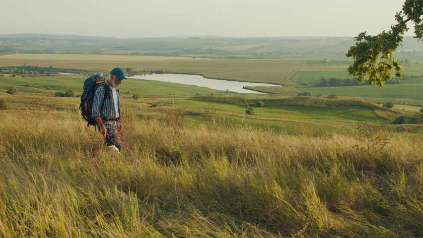 Cardiovascular Health, Mental Wellness, Active Aging. Senior Man Hikes in the Mountains, Enjoying Retirement and Nature. Inspiring Scene of Freedom, Strength, and Positive Aging