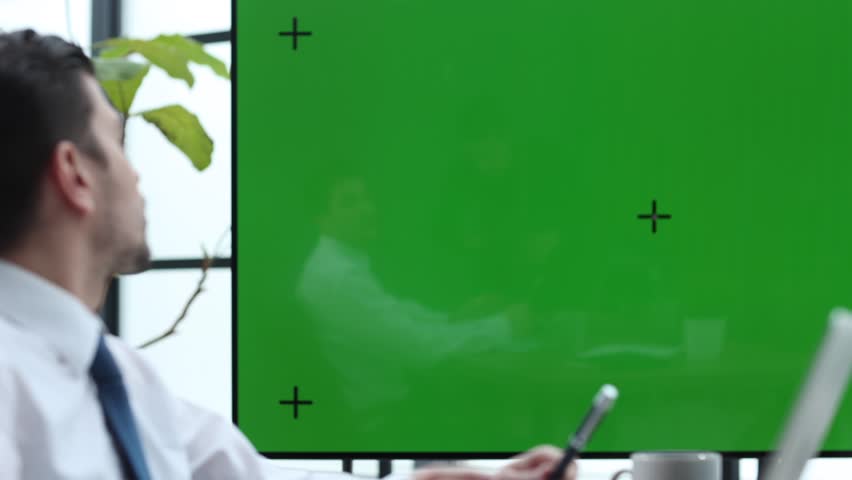 Male businessman in close-up working on a laptop green screen