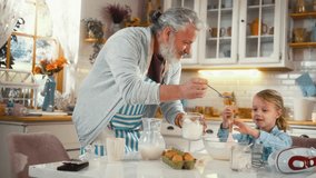 Cheerful grandfather and his cute little grandson are having fun and laughing, making pancakes in the kitchen. - Powered by Shutterstock - Get 15% off with code: PIKWIZARD15