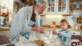 Cheerful grandfather and his cute little grandson are having fun and laughing making pancakes in the kitchen. Playful cheerful grandfather dancing in kitchen while making pancakes with his grandson. - Powered by Shutterstock - Get 15% off with code: PIKWIZARD15