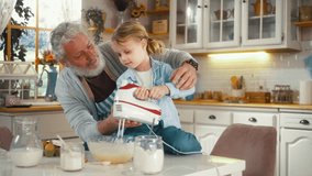 Smiling Little boy of 5 years using mixer machine to make pancake batter with his grandfather in the kitchen. - Powered by Shutterstock - Get 15% off with code: PIKWIZARD15