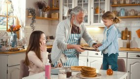 Grandpa and grandchildren share a fun morning baking pancakes together, with a little pancake-flipping mishap. Family bonding time and a generational joy kitchen at home. Funny moment - Powered by Shutterstock - Get 15% off with code: PIKWIZARD15