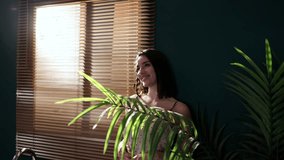 Woman enjoying sunlight through blinds in stylish apartment - Powered by Shutterstock - Get 15% off with code: PIKWIZARD15