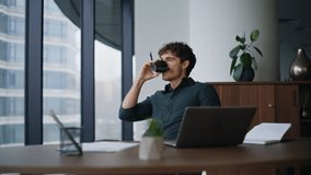 Company professional thinking on project sitting modern workplace holding pencil. Pensive businessman pondering ideas drinking coffee in office. Thoughtful manager looking laptop creating startup. - Powered by Shutterstock - Get 15% off with code: PIKWIZARD15