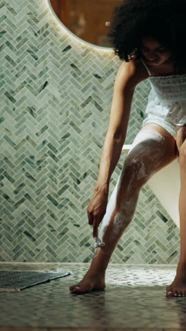 Beauty, girl and shaving legs in bathroom for skincare routine, depilation cream and self care in home. Cosmetics, woman and hair removal with razor tool for personal hygiene or cleaning in morning