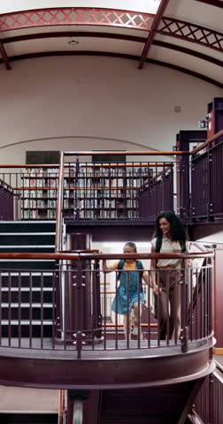 Library, child and woman with books for information, learning or knowledge for academic tutor. Study session, student and education with girl for scholarship, walking people and project support
