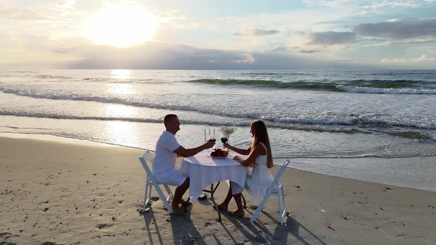 A couple in love enjoys a delightful dinner on the ocean beach