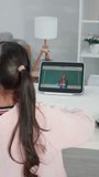 Rear view of young student learning online class with teacher at home. Adorable child student wearing headphones, using digital tablet study from school tutor by virtual remote online in living room. - Powered by Shutterstock - Get 15% off with code: PIKWIZARD15