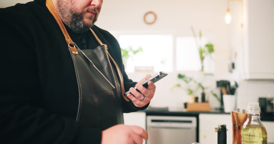 Cooking, phone and seasoning with man in kitchen of home for preparation of meal or supper. Food, ingredients and recipe with chef at counter in apartment for diet, healthy eating or nutrition