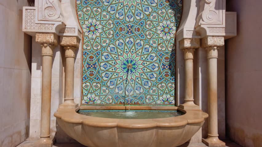 A drinking fountain decorated with traditional Moroccan tiles in the Hassan II Mosque square in Casablanca, Morocco.
