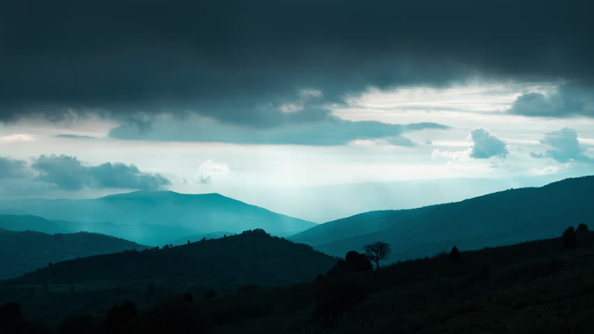 Timelapse mountains. Cloud falls on top of mountain and floods everything around with fog, like a tsunami wave. Nature is amazing. Nature miracle. Cinematic cloud timelapse nature background.