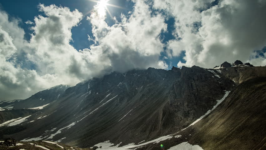 Timelapse mountains. Gloomy mountain landscape. Arashan. Sky is overcast with gray clouds. Sun disappears behind clouds completely. Force of nature, power. Ecology of Asia. Travel in happiness