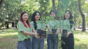 Happy Asian volunteers holding saplings to help plant trees to help reduce global warming. Save the world. - Powered by Shutterstock - Get 15% off with code: PIKWIZARD15