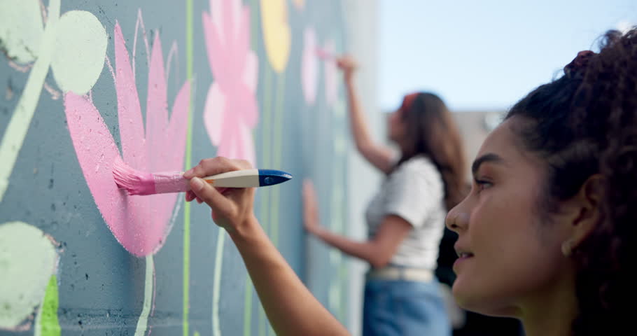Wall art, girl and painting mural with brush for creativity, community project and student hobby. Women, friends and artist people in city with DIY decor, painter and flowers with expression outdoors