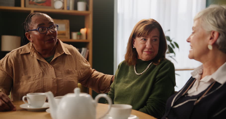 Nursing home, senior women and morning tea with conversation, discussion and reunion in living room. Old people, friends or pensioners with coffee break, talking or explain with retirement or support