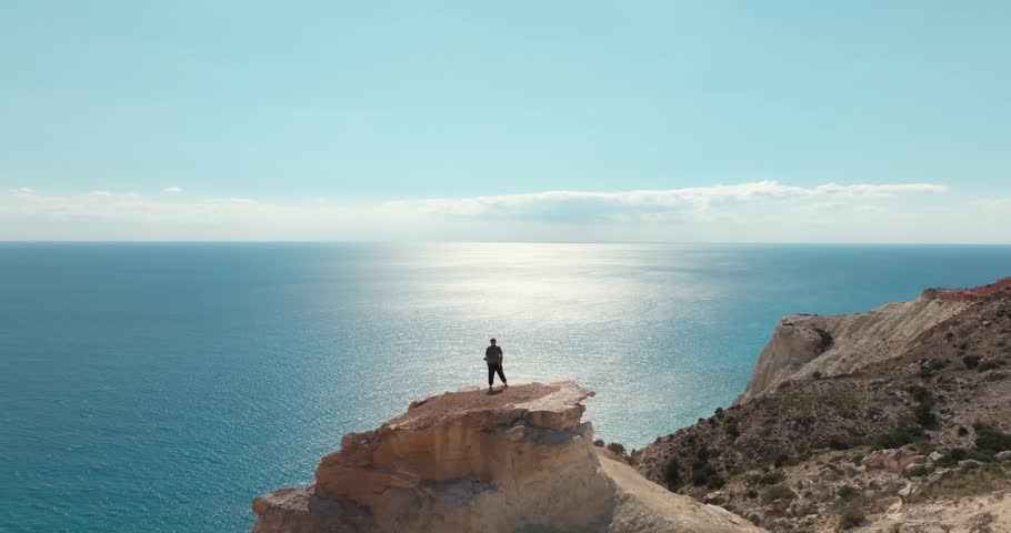 Aerial of the Aphrodite trail in Cyprus. Hiking a man on the top of a cliff with a cliff on the birch of the Mediterranean Sea, tourism is more expensive. High quality 4k footage