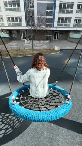 Rear view of Caucasian woman swinging on children