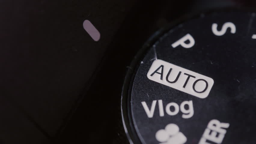 Close-up: photographer selecting the shooting mode on a professional camera. Digital camera control ring. Different shooting modes. SLR mode dial ring rotation. Rotates the mode selection wheel