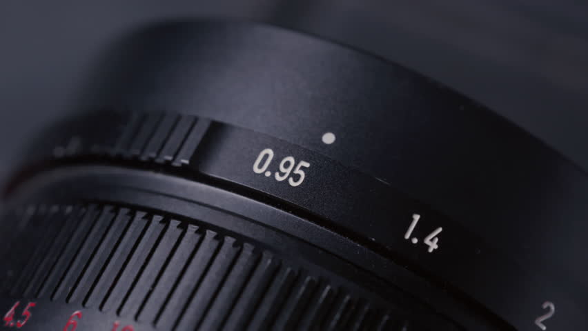 Closeup: Aperture ring changing on camera old Lens, adjusting F-Stop number and iris, showing aperture scale and ring shifting. Professional photographer adjusting lens aperture stop. Close up shot